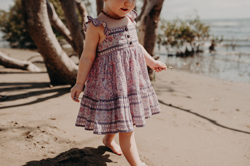 Bohemian style, Kids cotton dress featuring an exclusive placement print in pink, frilled sleeves and coconut buttons. Exclusive to We the Wild Collective