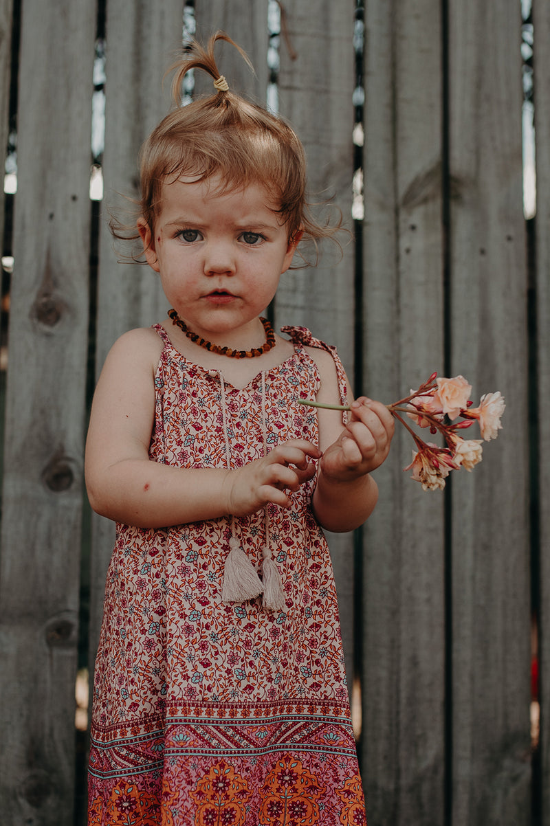 Kids Bohemian inspired, floral printed dress. Adjustable straps, border print and cotton neck tassels. Border floral print in multi colour